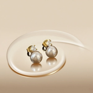 Elegant gold titanium earrings featuring a sparkling zircon stone and large round pearl