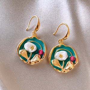 Macro view of French vintage floral drop earrings with teal enamel and white flower detail.
