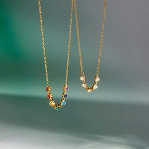 Close-up of gold-plated stainless steel necklaces with colorful and clear heart zircons.