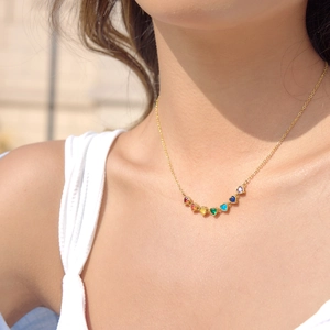 Close-up of a model wearing a rainbow heart zirconia necklace in gold finish