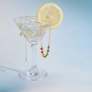 Detail of gold stainless steel necklace with colorful heart-shaped zircon pendants.