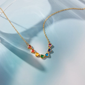Macro detail of rainbow heart-shaped cubic zirconia necklace in gold plated titanium steel