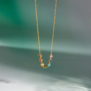 Macro view of dainty 18k gold plated necklace with colorful heart-shaped zircons