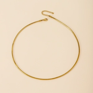 Close-up of gold snake bone chain necklace with lobster clasp and adjustable tail chain