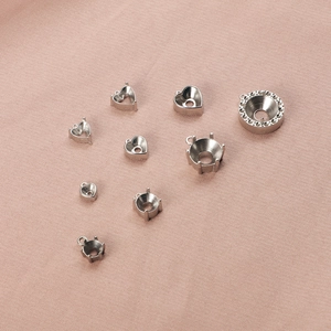 Detailansicht verschiedener Herz- und Rundkrallenfassungen aus Edelstahl für DIY-Schmuck.