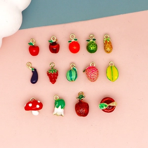 Close-up of colorful 3D enamel fruit and vegetable charms for DIY handmade jewelry making.