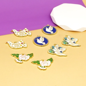 Detailed view of white and gold enamel bird charms with 'protect kids not guns' text.