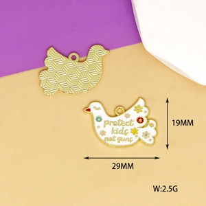 Detailed macro view of white enamel dove charm with colorful floral and text patterns