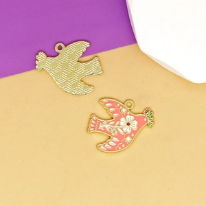 Close-up of pink enamel dove bird charms with floral patterns and textured gold back