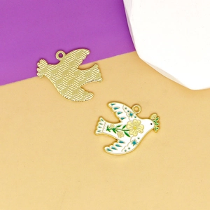 Detailed view of white enamel peace dove charm with floral pattern and gold-tone back