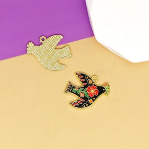 Macro detail of enamel peace dove charms featuring vibrant floral art and textured back