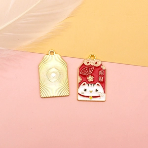 Lucky omamori charm featuring a maneki-neko cat and wealth character in red enamel