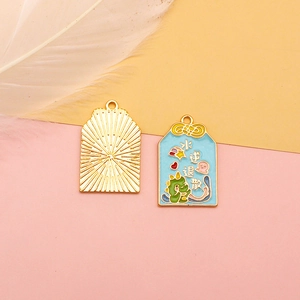 Enamel Omamori alloy charm detail with lucky Chinese characters and cute dinosaur motif.