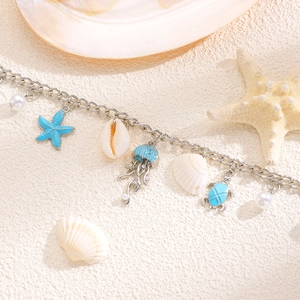 Dettaglio cavigliera boho con stelle marine turchesi, tartarughe e ciondoli a conchiglia