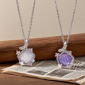 Detailed close-up of shell-shaped pendants in white and purple with zircon accents