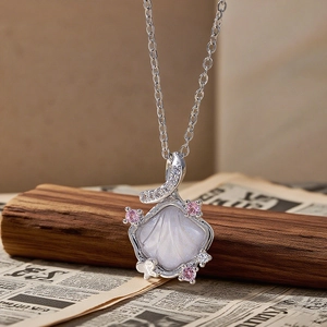 Detailed close-up of shell pendant with white mother-of-pearl and pink crystals
