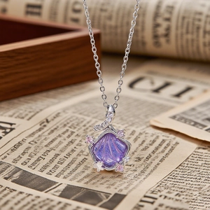 Close-up of shell pendant with purple pearl center and pink zircon stone accents