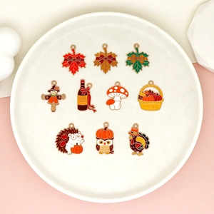 Close-up of Thanksgiving-themed alloy drip oil charms with turkey and maple leaf designs.