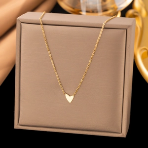 Minimalistische goldene Herz-Halskette auf einer Schmuckschatulle mit polierter O-Kette
