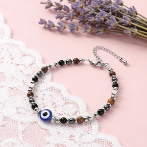 Close-up of triple protection bracelet with 6mm tiger eye, obsidian and evil eye charm.