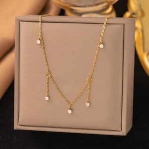 Détail du collier en acier inoxydable doré avec des pampilles de zircon scintillantes