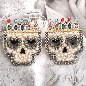 Detailed close-up of skull crown earrings with colorful rhinestones and white pearls