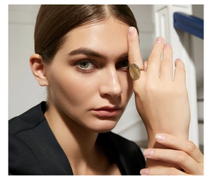 Großer goldener ovaler Ring mit Metallstruktur getragen von einem Model im Nahaufnahme