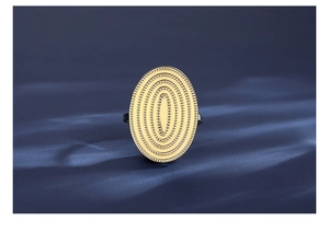 Makroaufnahme eines goldenen Statement-Rings mit geschichteter Textur auf blauem Seide
