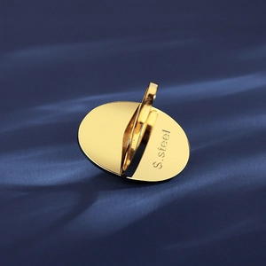 Golden stainless steel adjustable open ring with oval flat surface on blue fabric