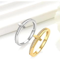 Detail of silver and gold cross rings with pavé cubic zirconia on minimalist bands