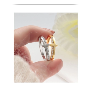 Close-up of gold and silver cross rings with sparkling pave set cubic zirconia stones