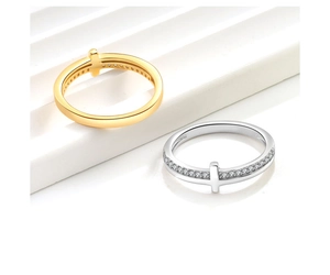 Close-up of cross-shaped rings with micro-pave cubic zirconia on polished gold and silver bands