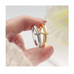 Macro detail of silver and gold cross rings with pavé cubic zirconia settings