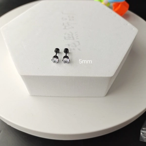 Detailed macro view of 5mm black titanium steel stud earrings with white cubic zirconia