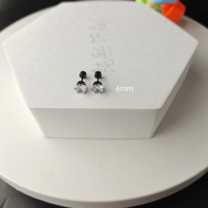 Detailed macro view of 6mm black stainless steel stud earrings with white cubic zirconia