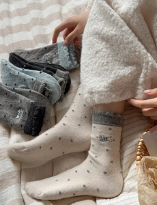 Detail of wool socks featuring polka dots, puppy embroidery, and ruffle edges