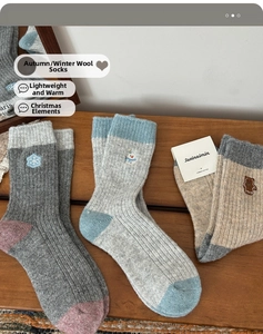 Detail of wool socks with festive embroidery on a rustic wooden background