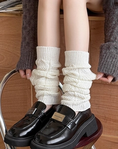 Detailed knit texture of white leg warmers paired with black loafers in Y2K style