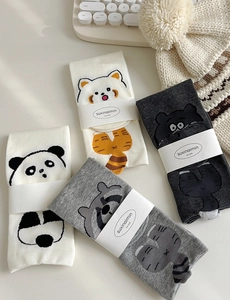 Flat lay of four pairs of cartoon animal cotton socks with cute raccoon and panda designs