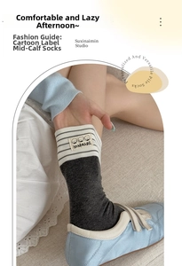 Detail of striped grey cotton socks with handmade dog label and blue canvas shoes