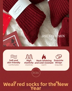 Close-up of red ribbed wool socks with brand packaging on a festive background