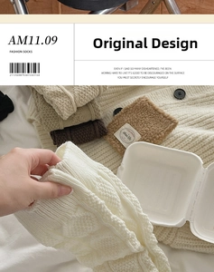 Detailed view of chunky cable knit leg warmers featuring a square fabric brand label
