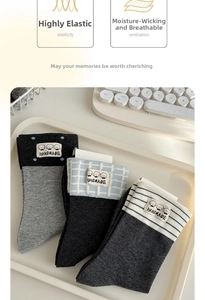 Detail of striped and patterned cotton socks with cute cartoon dog patches in a tray