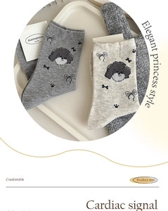 Detail of grey cotton socks featuring cute cartoon dog patterns and black bows