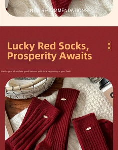 Detail of dark red wool socks featuring vertical ribbing and a gold oval metal tag