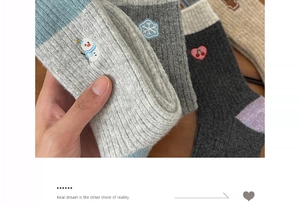 Macro detail of winter thermal wool socks with festive snowman and snowflake embroidery