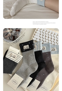 Detail view of cotton mid-calf socks with cute cartoon dog patches and stripe patterns