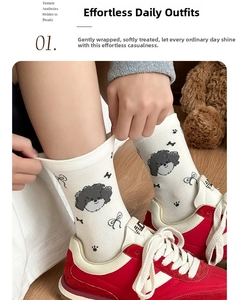 Detailed view of white cotton socks with cute cartoon puppy pattern and black paw prints