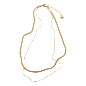 Detail of double-layer gold snake chain necklace with small heart pendant and lobster clasp