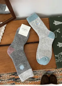 Detailed view of warm wool blend socks with cute snowflake and snowman embroidery